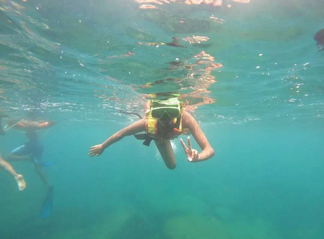 Guest giving a peace sign while snorkeling at Angel Rock, Sri Lanka
