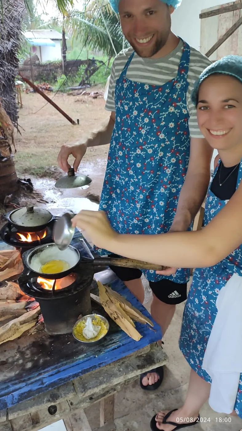 Guests cooking egg hoppers over a traditional firewood stove at the Nilaveli cooking class