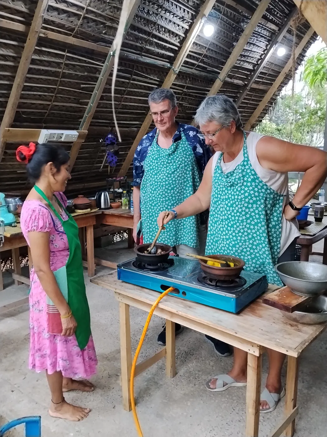 Nimali teaching guests curry cooking at the stove in her traditional kitchen