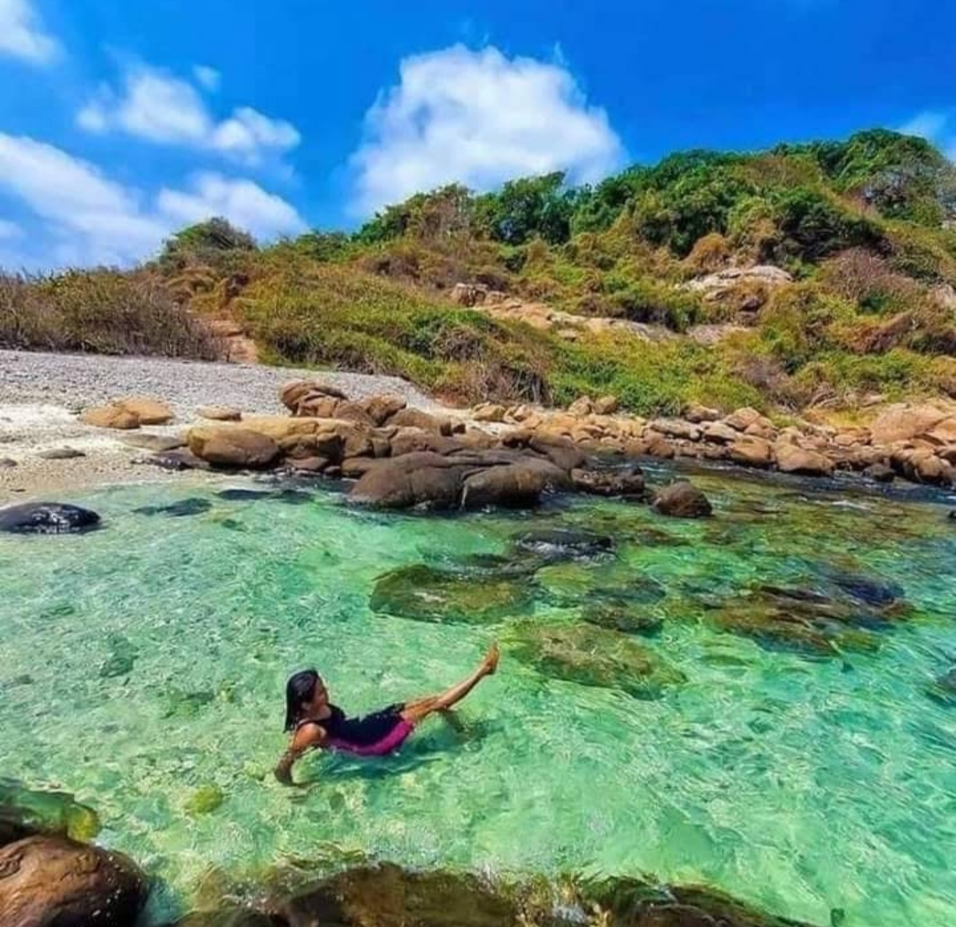 Traveler relaxing in the crystal-clear turquoise lagoon of Pigeon Island near Nilaveli Beach