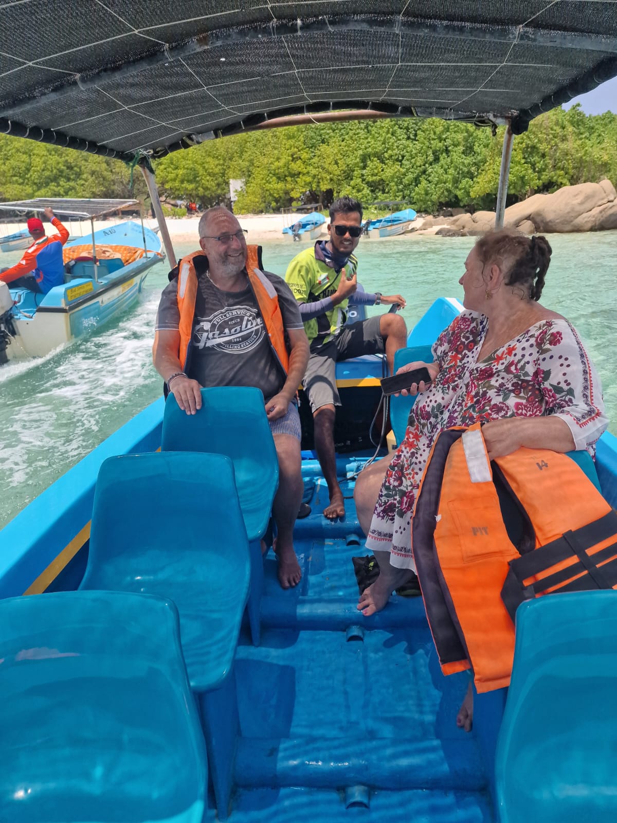 Happy travelers with life jackets aboard a Pigeon Island Tours boat departing Nilaveli Beach