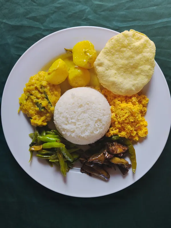 Rice and curry plate with dhal, potato curry, papadam and pol sambol