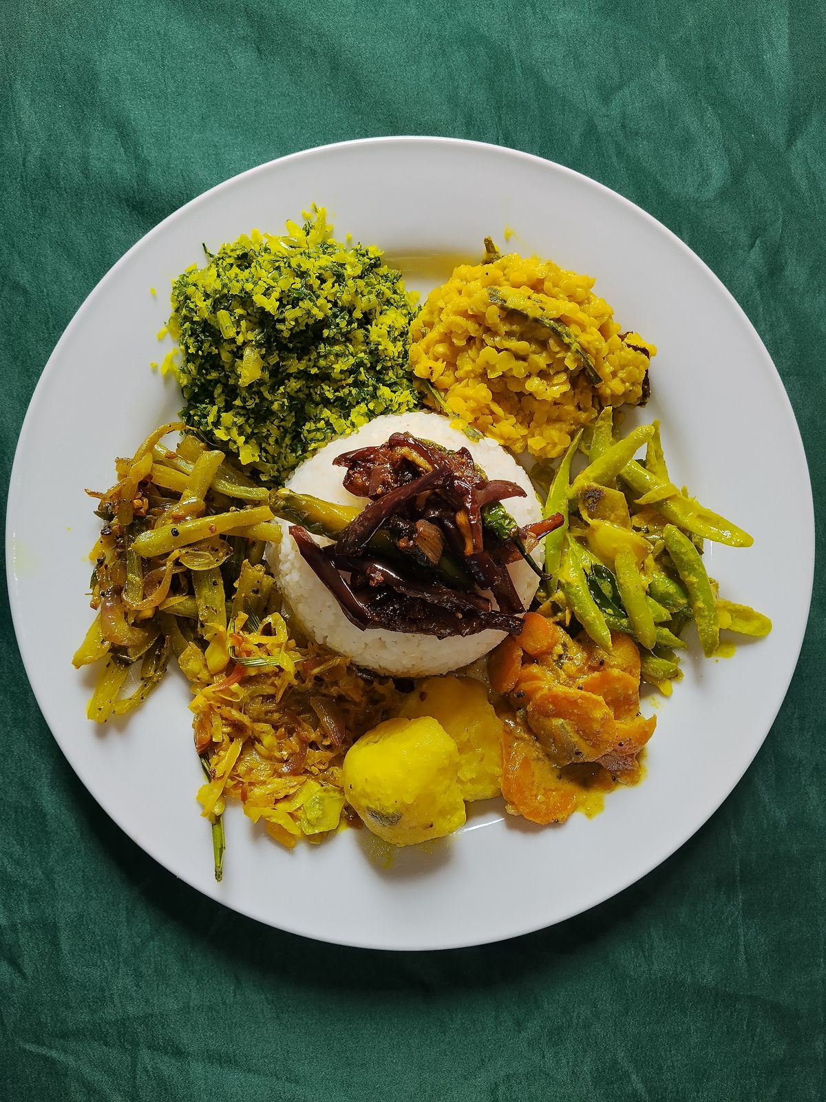Sri Lankan rice and curry plate in Nilaveli with gotu kola sambol, dhal curry, brinjal moju, green beans, cabbage, potato and carrot curries